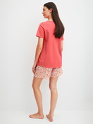Damen-Model trägt Kurz-Pyjama aus 100% Baumwolle in Rot, Floral aus Serie Flower Nights von CALIDA, Rückansicht
