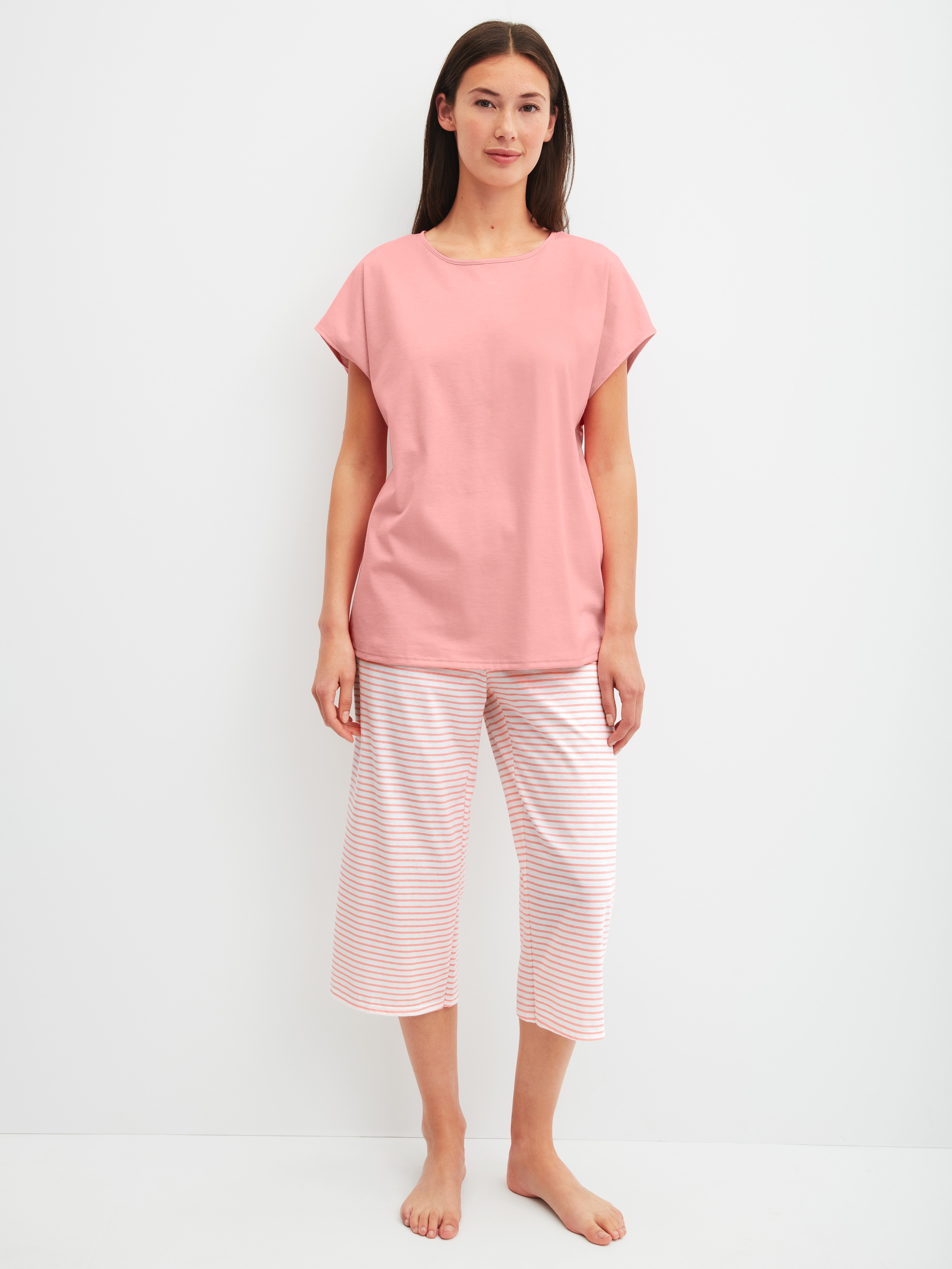 Women model is wearing Capri Pyjama made of 100% Cotton in Orange, Patterned from the Lovely Nights series by CALIDA, Front view