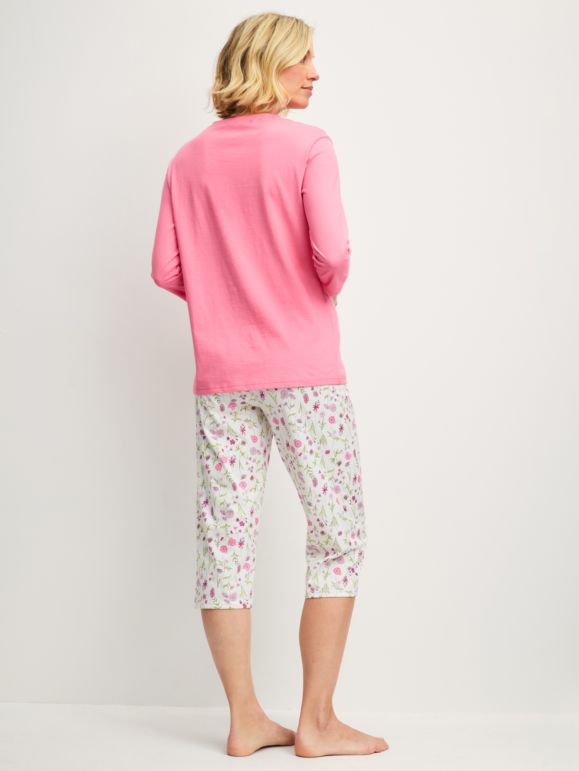 Women model is wearing Capri Pyjama made of 100% Cotton in Pink, Patterned from the Cotton Special series by CALIDA, Back view