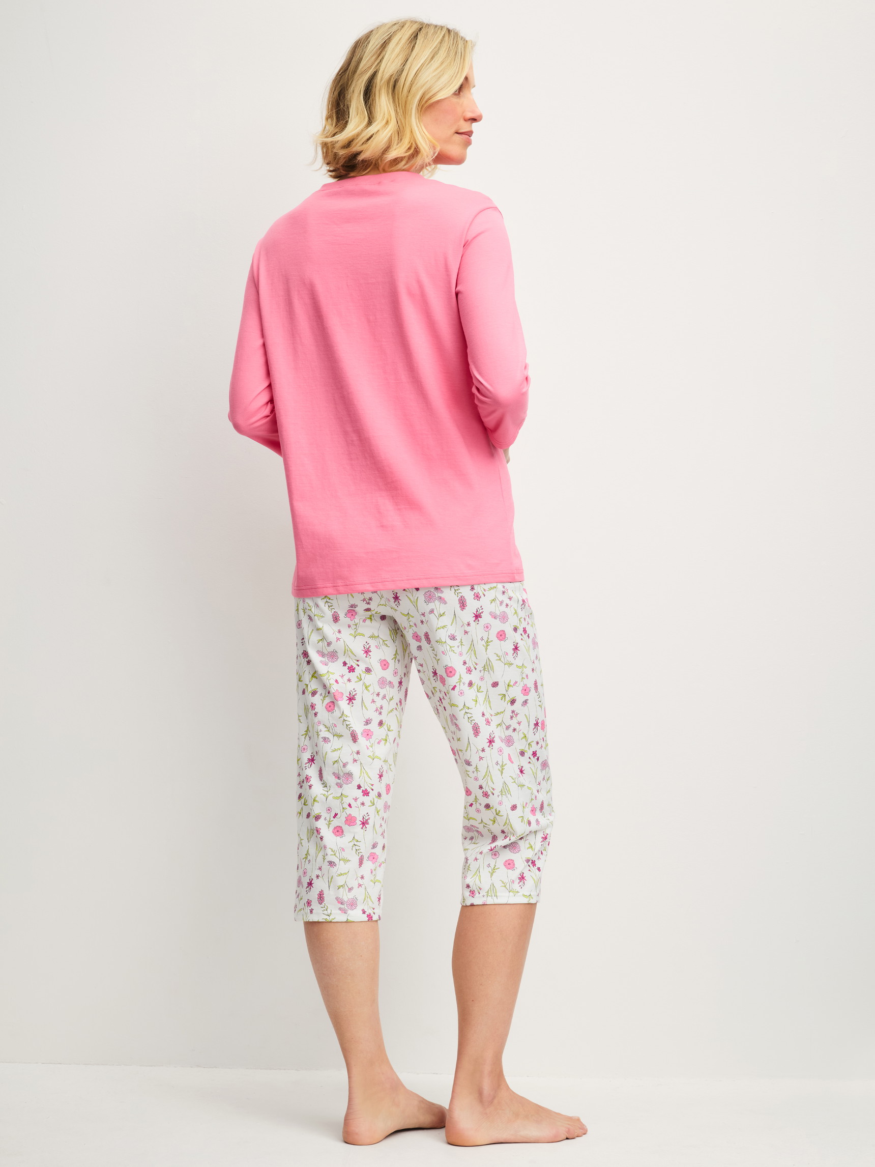 Damen-Model trägt Capri-Pyjama aus 100% Baumwolle in Rosa, Gemustert aus Serie Cotton Special von CALIDA, Rückansicht