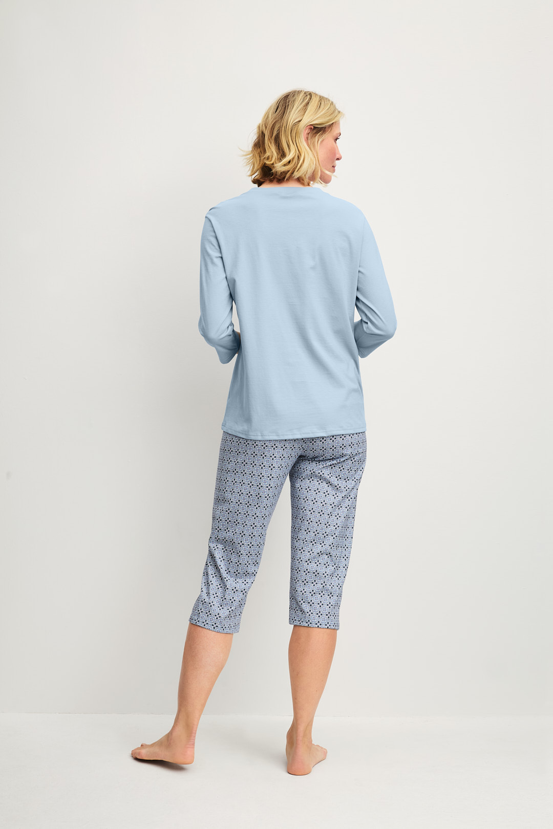Women model is wearing Capri Pyjama made of 100% Cotton in Grey, Patterned from the Cotton Special series by CALIDA, Back view