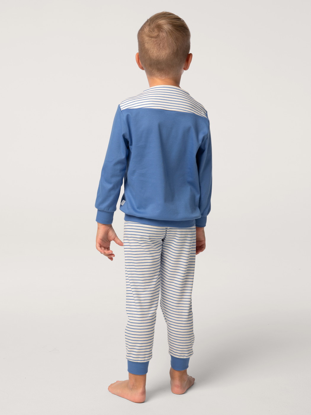 Kids model is wearing Pyjama with cuff made of 100% Cotton in Blue,  from the Toddlers Youngster series by CALIDA, Back view