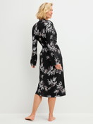 Damen-Model trägt Kimono, Länge 120cm aus Modal in Schwarz, Floral aus Serie Glimmer M&M von CALIDA, Rückansicht